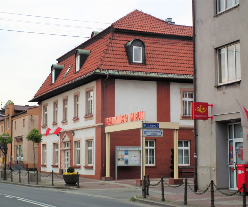 Budynek Urzędu Miasta Imielin z czerwonym dachem i polskimi flagami. O historii miasta przeczytasz na Eska Śląskie.