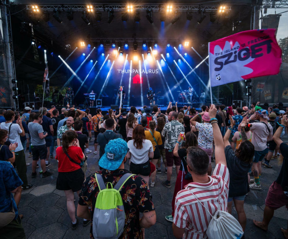Tłum ludzi pod oświetloną sceną festiwalu Sziget. Po prawej różowa flaga z logo imprezy. O gwiazdach edycji 2026 pisze Eska.