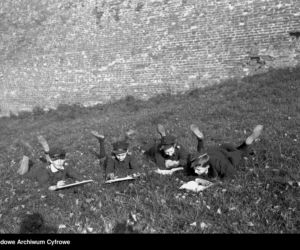 Chłopcy przeglądający książki na trawie przed murami Wawelu (1928 r.)