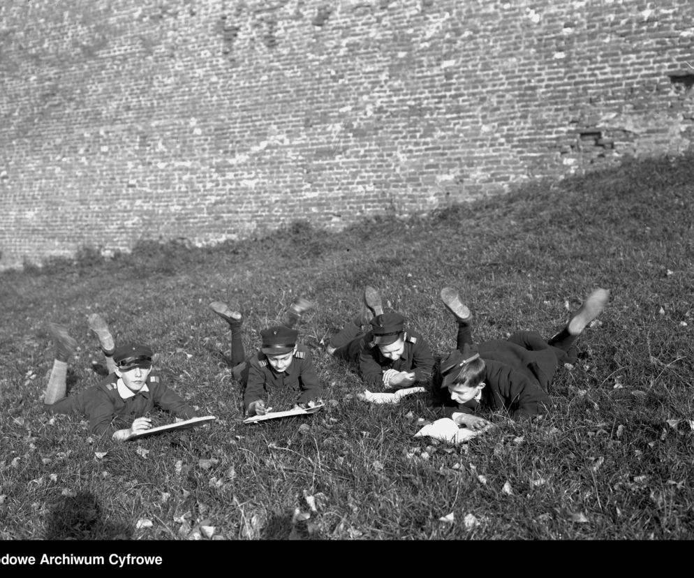 Chłopcy przeglądający książki na trawie przed murami Wawelu (1928 r.)