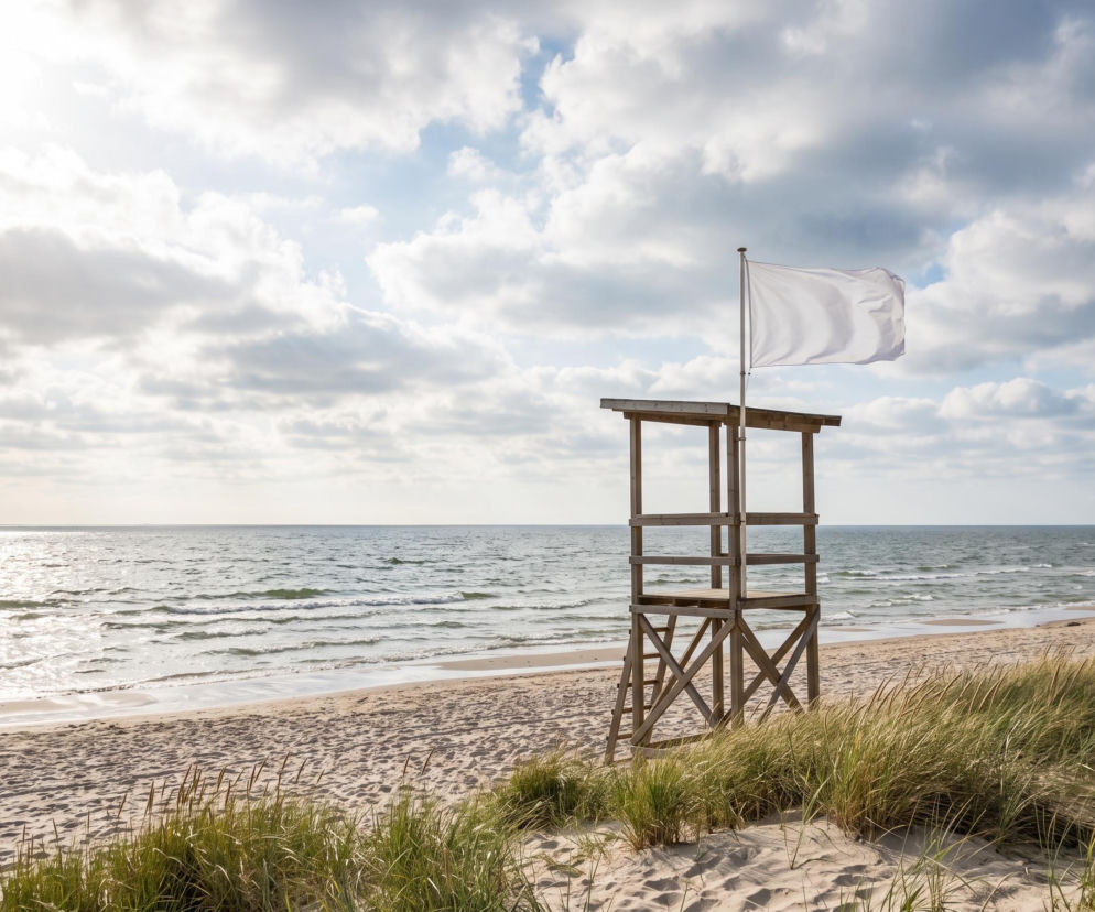Wieża ratownicza z białą flagą na pustej plaży w Grzybowie. O pogodzie nad morzem przeczytasz na SE Szczecin.