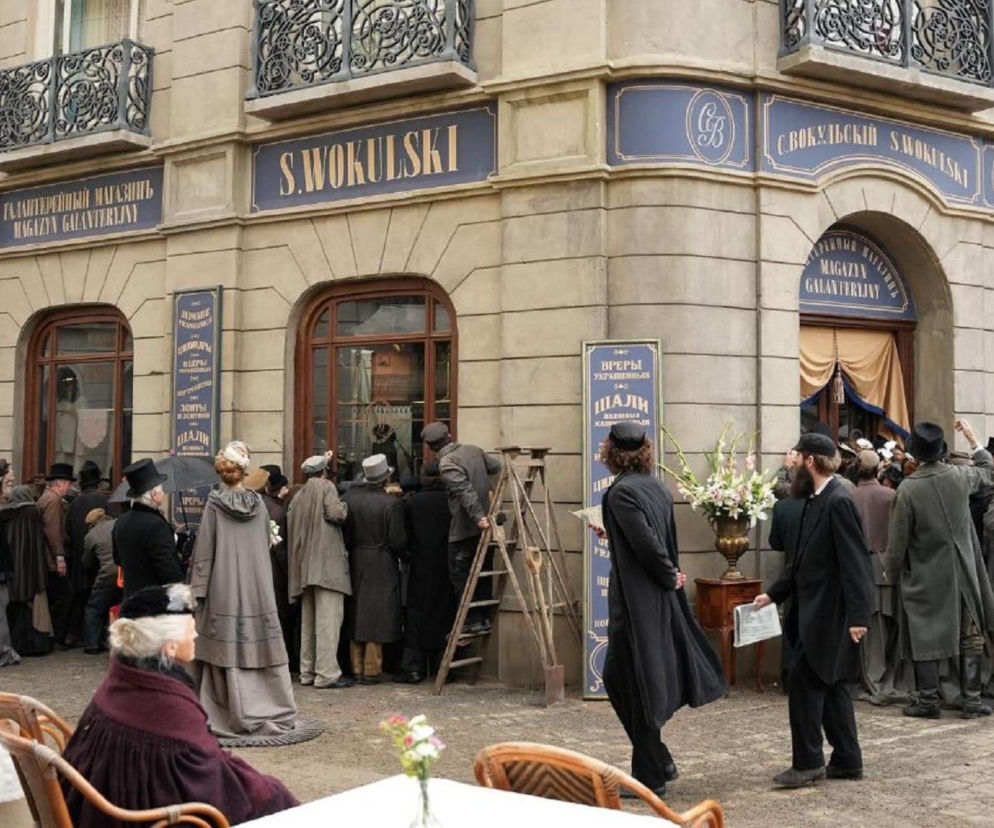 Tłum ludzi w strojach z epoki przed filmowym sklepem Wokulskiego w Warszawie. O kulisach budowy dekoracji czytaj na Architektura.