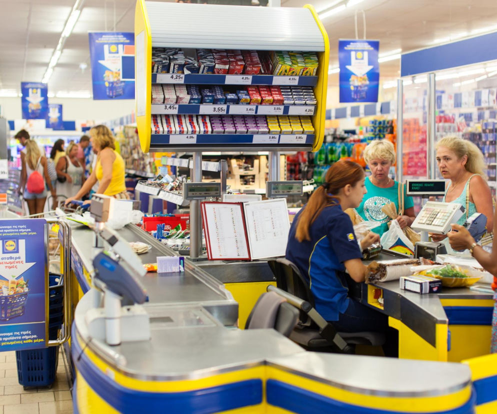 Kasjerka obsługuje klientki przy kasie w sklepie Lidl. O nowych zarobkach w sieci przeczytasz na SE Lublin.