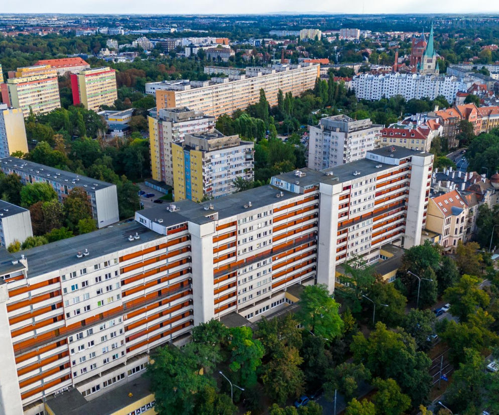 Długi wrocławski galeriowiec otoczony zielenią i innymi blokami. O historii tych budynków przeczytasz w serwisie Architektura.