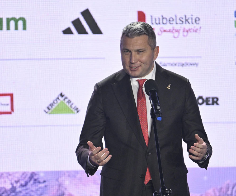 Radosław Piesiewicz przemawia do mikrofonu na tle logotypów sponsorów. O jego zatrzymaniu przeczytasz na SE Supersport.