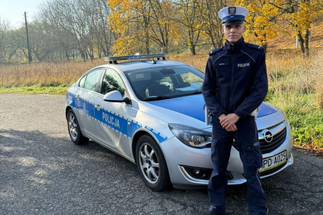 Policjant Łukasz Lenart stoi przed radiowozem marki Opel. O akcji ratunkowej w Lublinie przeczytasz na SE Lublin.