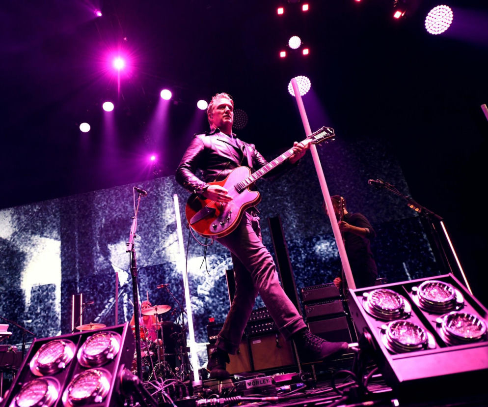Josh Homme z Queens of the Stone Age gra na gitarze podczas koncertu. O ich występie w Warszawie przeczytasz na EskaRock.