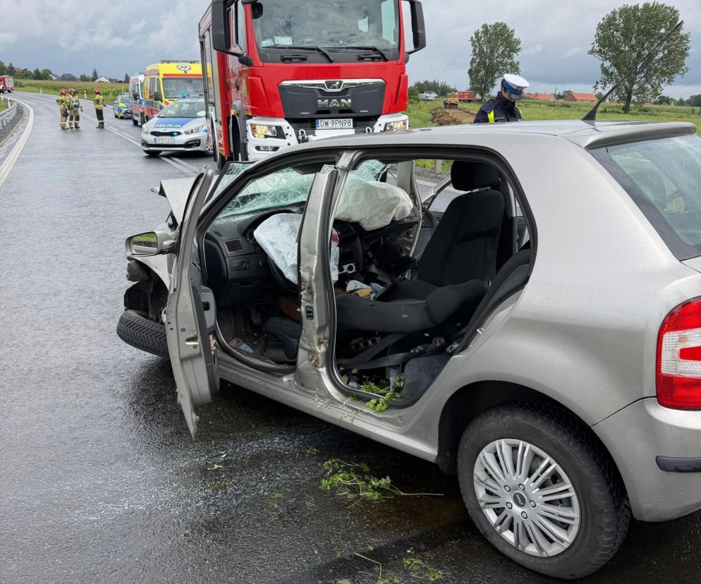 Zniszczony samochód osobowy na drodze obok wozu strażackiego i policji. O wypadku przeczytasz na Eska Wrocław.