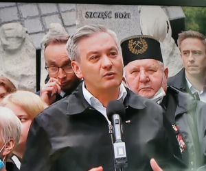 Robert Biedroń na tle religijnego hasła