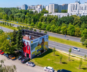 Otoczony reklamami dom przy Dolinie Służewieckiej w Warszawie
