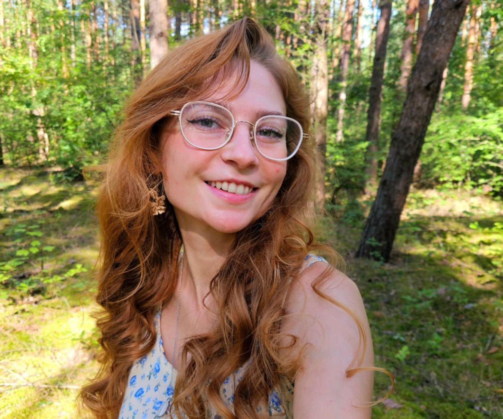 Uśmiechnięta influencerka Najjjka w okularach na tle lasu. O jej kontrowersyjnych wypowiedziach przeczytasz w Eska.