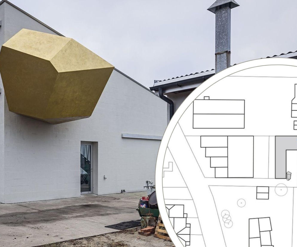 Zewnętrzny widok na pracownię Pawła Althamera w Wesołej, gdzie na białej elewacji widnieje złota kapsuła kosmonauty – intrygujący element architektoniczny. Na drugim planie fragment planu sytuacyjnego. Więcej o tym na Architektura Murator Plus.