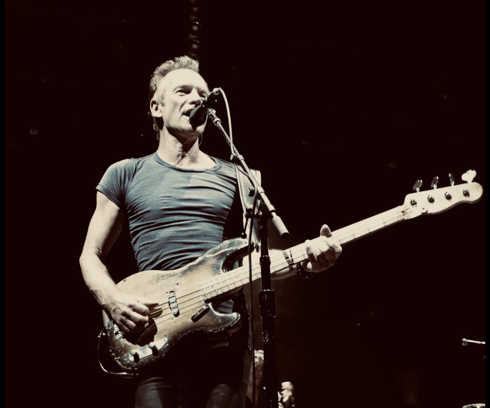 Sting śpiewa do mikrofonu i gra na gitarze basowej podczas koncertu. O występach w Polsce przeczytasz na EskaRock.