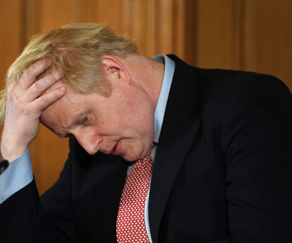 Boris Johnson zamyślony, trzyma się za głowę. O ewakuacji polityka po ataku dronów przeczytasz na SE Polityka.