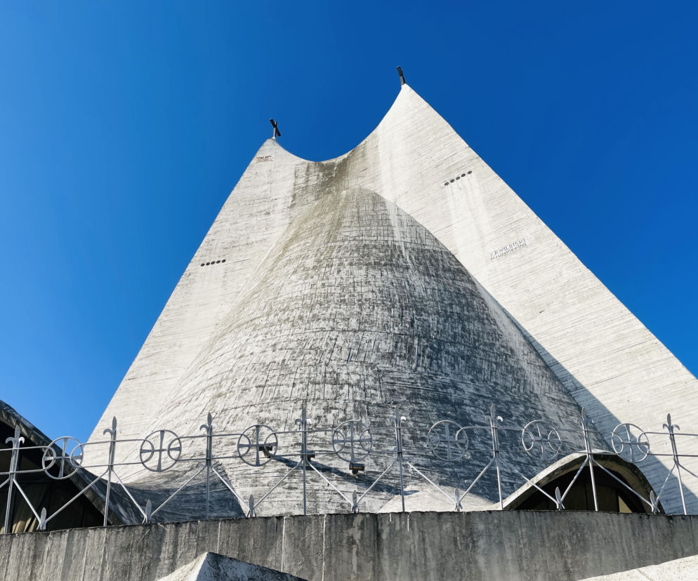 Betonowa bryła kościoła Miłosierdzia Bożego w Kaliszu na tle nieba. O tej architekturze przeczytasz w serwisie Architektura.