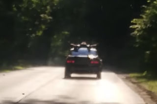 Od upału mu odbiło! Jechał na dachu BMW i zaczął się rozbierać - WIDEO