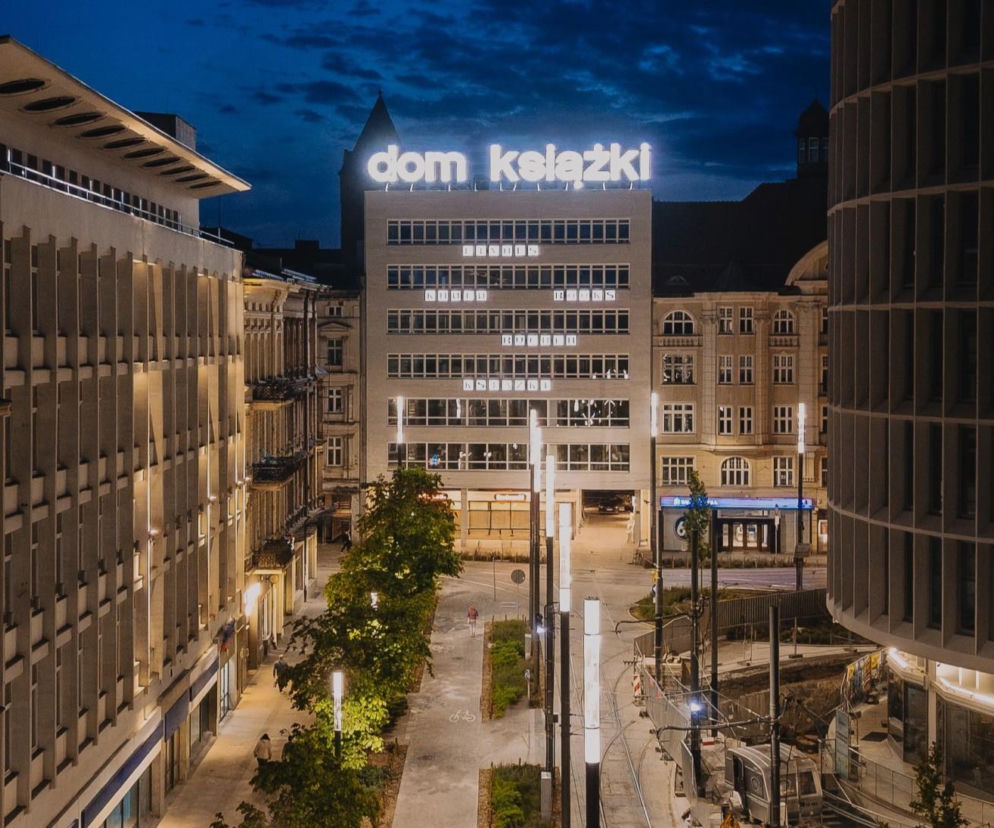 Odnowiony Dom Książki w Poznaniu nocą z jasnym napisem na dachu. O laureatach konkursu NAWW przeczytasz na Architektura.