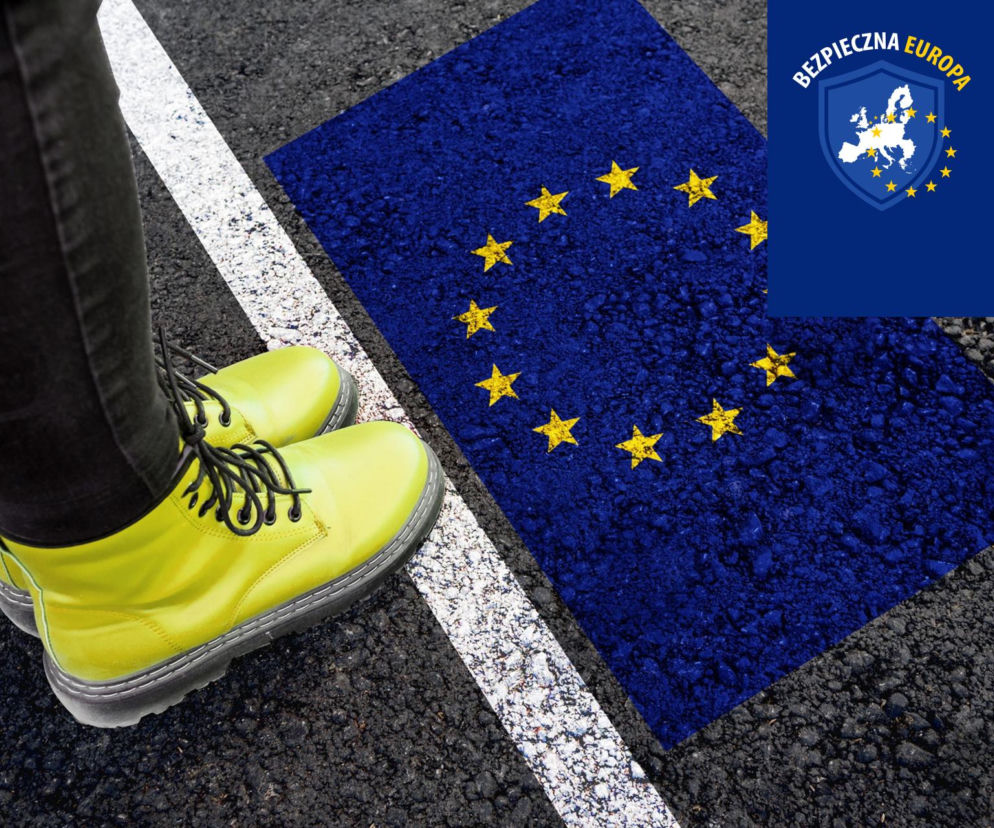 Nogi osoby w żółtych butach przed linią graniczną z flagą Unii Europejskiej. O ochronie granic UE przeczytasz na SE.