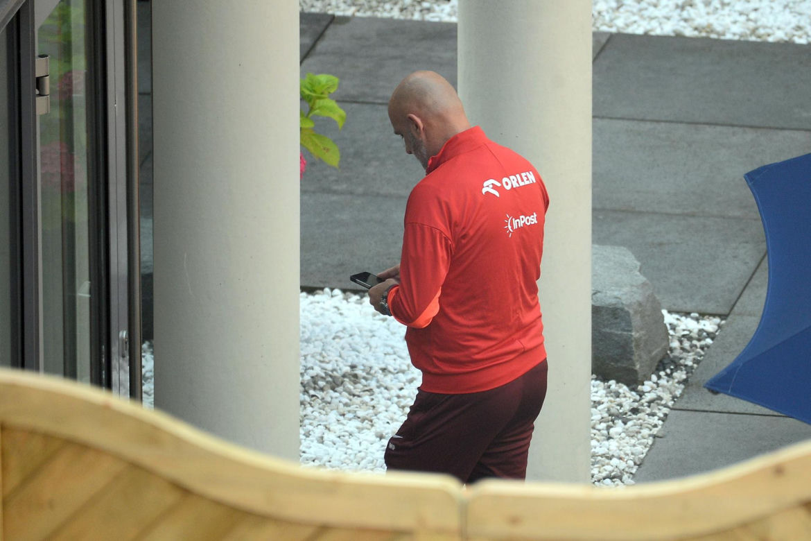 Michał Probierz przybity wpatruje się w telefon