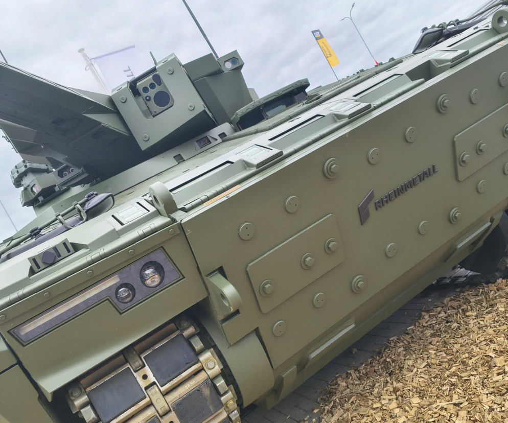 Bok opancerzonego pojazdu wojskowego z logo Rheinmetall. O zagrożeniach dla firm zbrojeniowych czytaj na SE Portal Obronny.