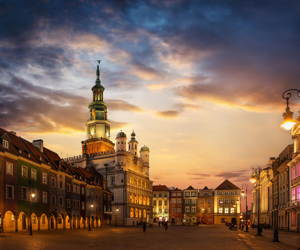 Rynek w Poznaniu o zachodzie słońca, z historycznymi kamienicami oświetlonymi ciepłym światłem i majestatycznym renesansowym ratuszem. Niebo mieni się odcieniami pomarańczu i granatu, symbolizując sukces Poznania jako lidera zdrowych miast, o czym przeczytasz na Poradnik Zdrowie.