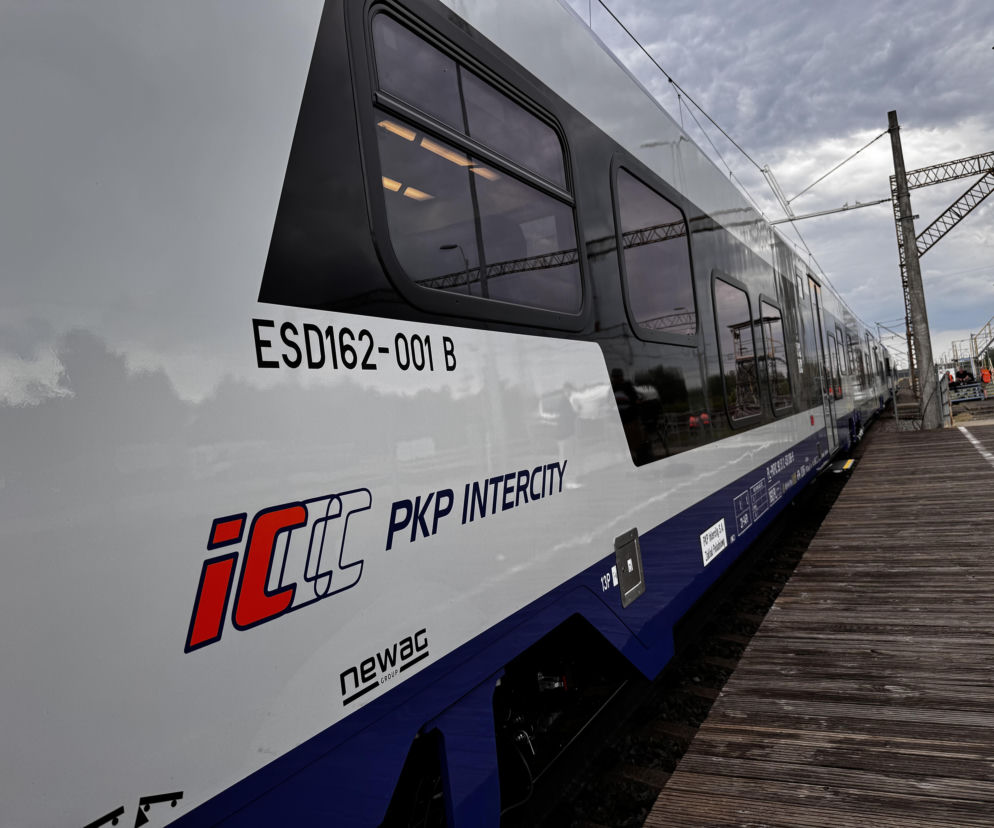 Nowoczesny pociąg PKP Intercity stoi na torach przy peronie. O inwestycjach spółki przeczytasz na SE Superbiz.