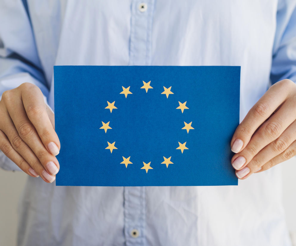 Dłonie osoby trzymającej flagę Unii Europejskiej. O referendum w Islandii przeczytasz na portalu Eska.