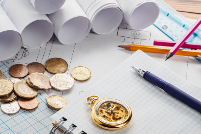 Rulony z projektami domów, notatnik, przybory piśmiennicze oraz pieniądze