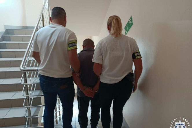 Dwoje policjantów prowadzi skutego mężczyznę po schodach. O znęcaniu się nad psem w gminie Secemin przeczytasz na SE.