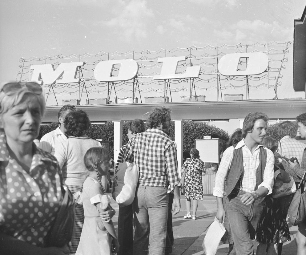 Historyczne czarno-białe zdjęcie szyldu „MOLO” z lat 60. w Sopocie, przedstawiające ludzi spacerujących przed budynkiem. To symbol architektury PRL, o którego przyszłości przeczytasz na portalu Architektura Murator Plus.