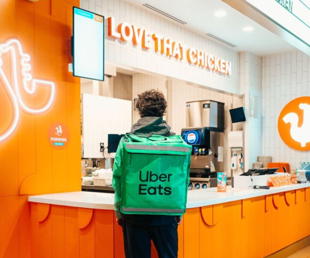 Kurier Uber Eats w restauracji Popeyes odbiera zamówienie. O współpracy sieci z dostawcą przeczytasz w Radiu Eska.