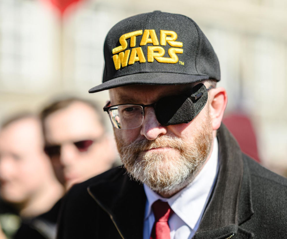 Europoseł Grzegorz Braun w czapce Star Wars i z opaską na oku. O karach dla polityka przeczytasz na SE Polityka.