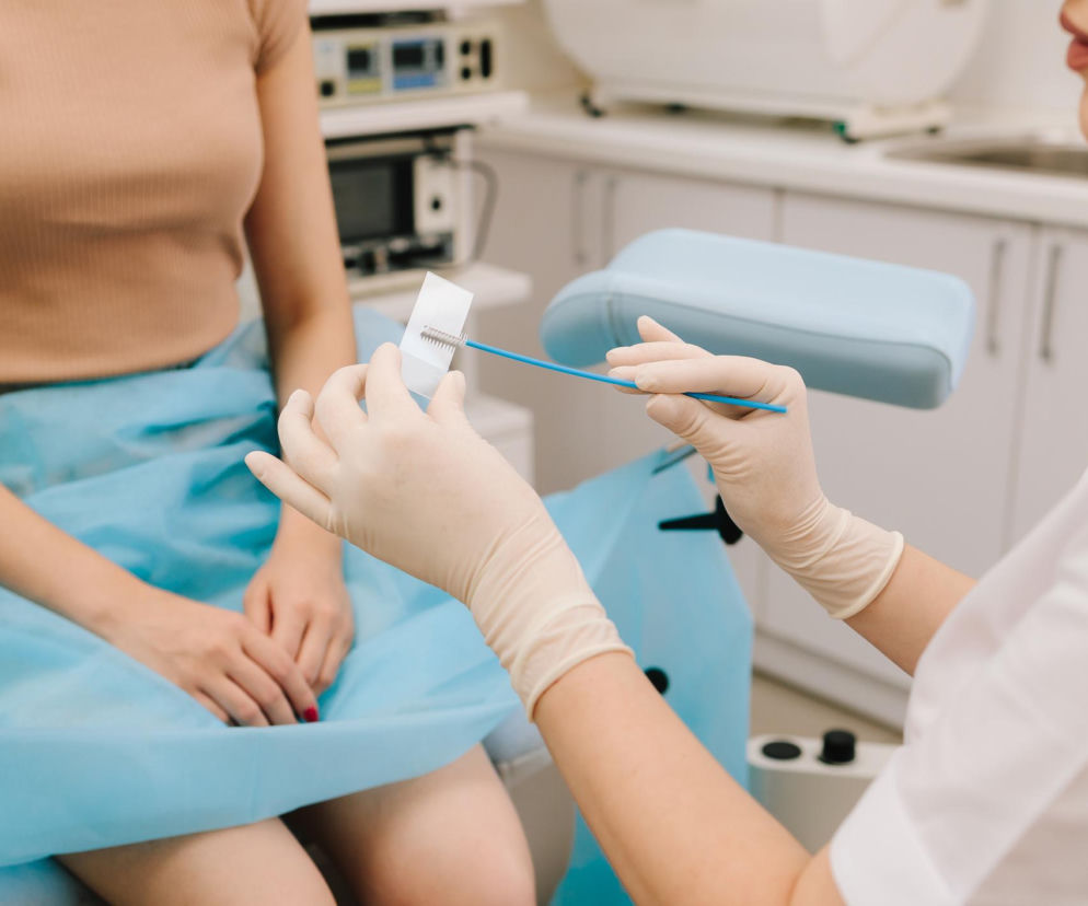 Ręce lekarki w rękawiczkach trzymające szczoteczkę cytologiczną. O nowych testach HPV HR przeczytasz na Poradnik Zdrowie.