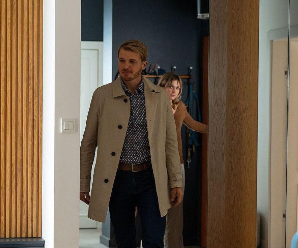 Mężczyzna w jasnym płaszczu i ciemnych spodniach wychodzi z pokoju, za nim stoi kobieta. Opis odcinka Na dobre i na złe, gdzie Beger nakryje Glorię z Kamilem, przeczytasz na portalu Super Seriale.