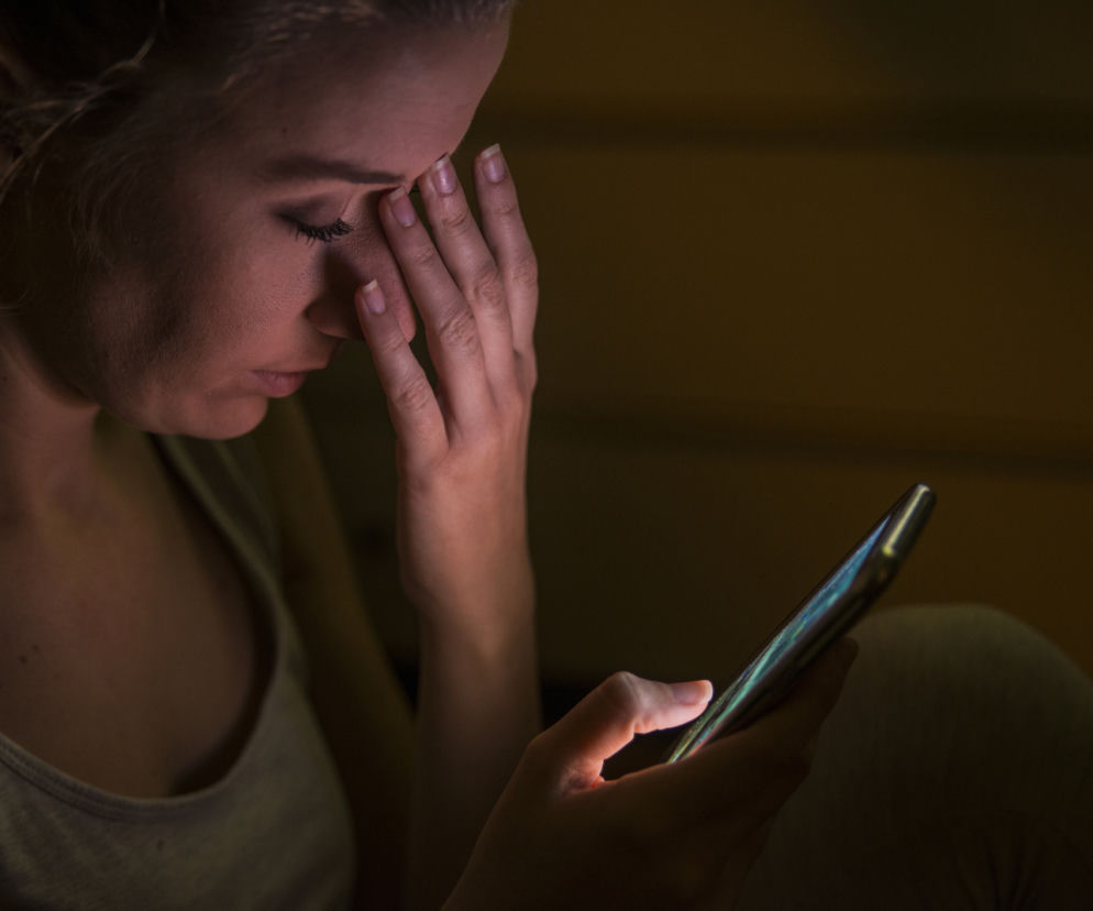 zaspana kobieta używa nocą telefonu