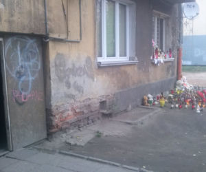 Przed blokiem, w którym zginęła kobieta i dwoje dzieci palą się znicze