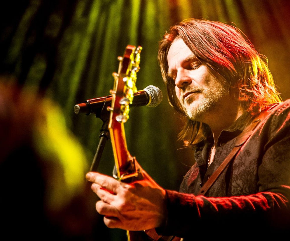 Ray Wilson gra na gitarze przy mikrofonie podczas koncertu. O jego występie w Tychach przeczytasz na EskaRock.