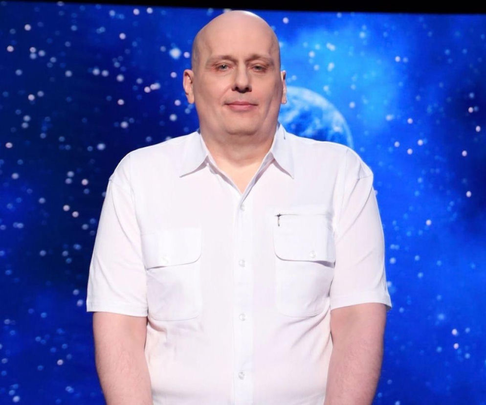 Rekordzista Sebastian Witkowski w białej koszuli na tle studia Jeden z dziesięciu. O sukcesie czytaj na Eska Śląskie.