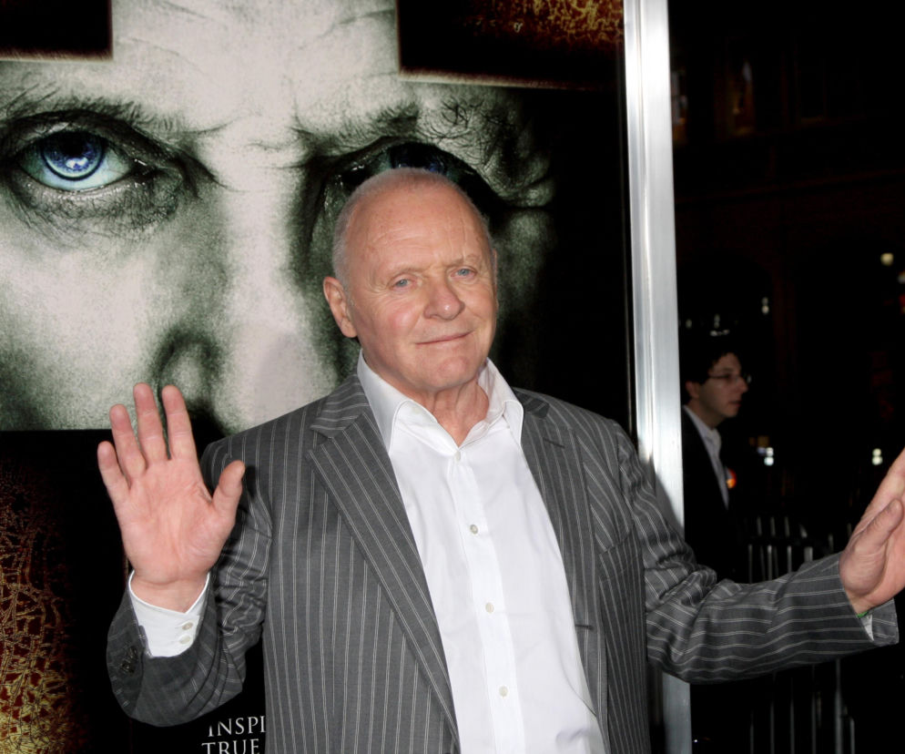 Aktor Anthony Hopkins na tle plakatu filmowego. O muzycznym debiucie gwiazdora przeczytasz na SE.