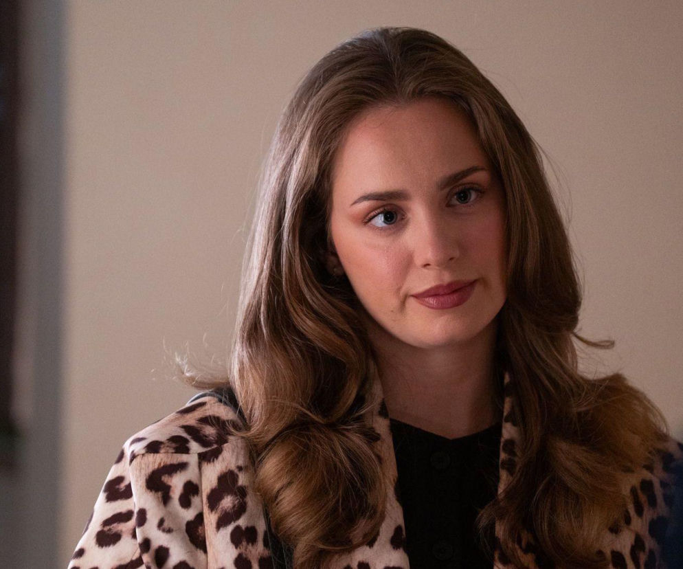 Aktorka Wiktoria Gąsiewska jako Oliwka Zbrowska w kurtce w panterkę, z delikatnym uśmiechem i makijażem, patrząca lekko w bok, odzwierciedlająca dylematy postaci w serialu „Barwy szczęścia”. Więcej o serialu przeczytasz na Super Seriale.