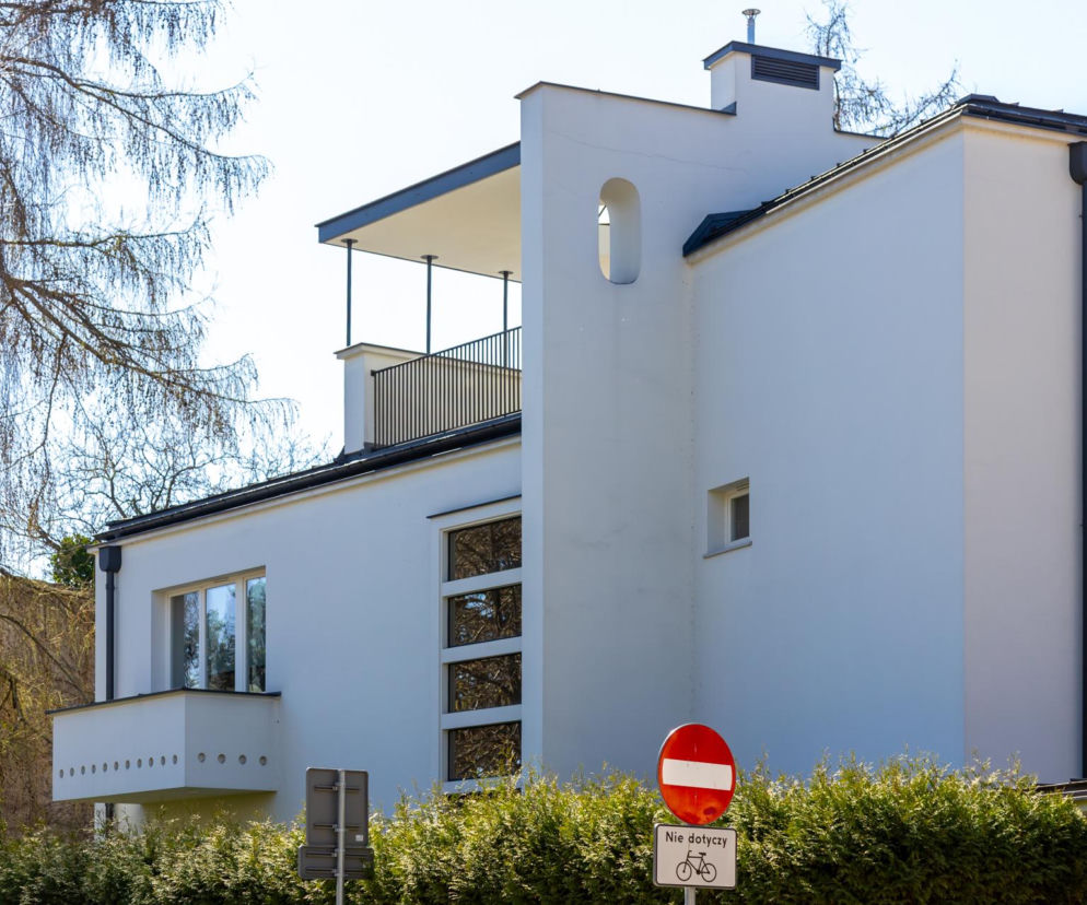 Biała modernistyczna willa Brzezińskich z tarasem i geometrycznymi detalami. O architekturze budynku przeczytasz na Architektura.