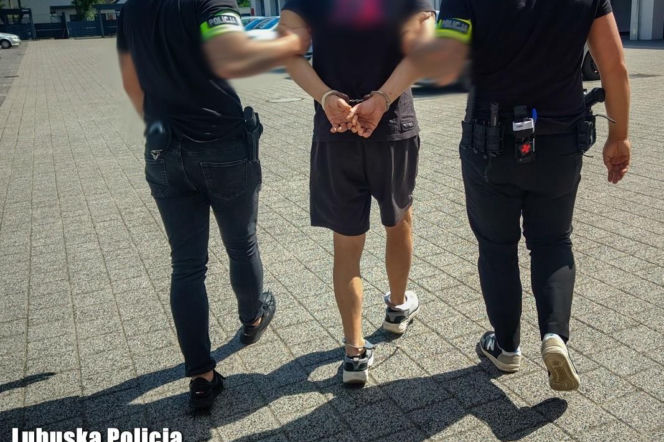 Policjanci prowadzą skutego kajdankami mężczyznę. O kradzieżach na Rap Stacji przeczytasz na Eska Leszno.