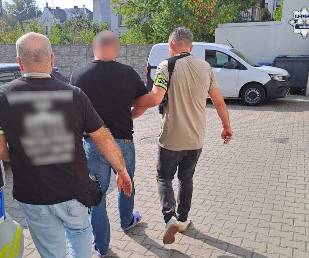 Dwaj funkcjonariusze prowadzą zatrzymanego mężczyznę. O ataku na motocyklistów w Koszęcinie przeczytasz na SE.