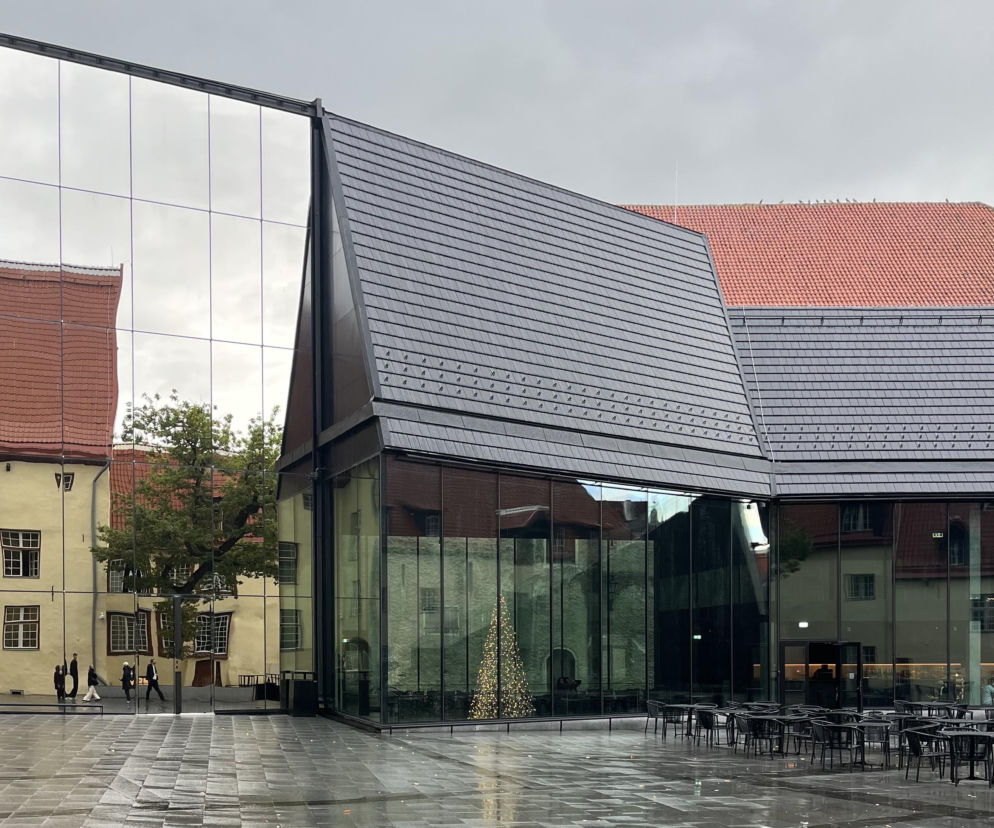 Szklana bryła Teatru Miejskiego w Tallinie odbijająca zabytkowe kamienice. O tej architekturze przeczytasz na Architektura.