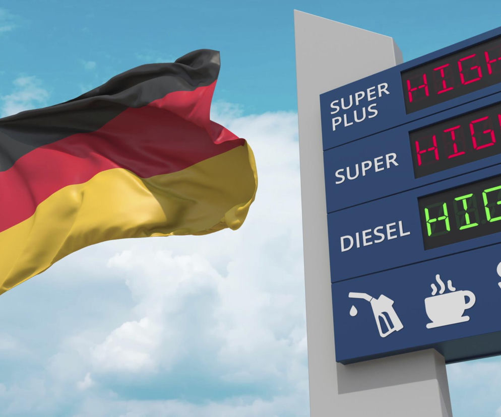 Flaga Niemiec na tle nieba obok cyfrowego pylonu stacji benzynowej z napisem HIGH przy wszystkich rodzajach paliwa. Ilustracja symbolizuje wysokie ceny paliw w Niemczech, co skłania ich obywateli do tankowania w Polsce, o czym przeczytasz na Super Biznes.