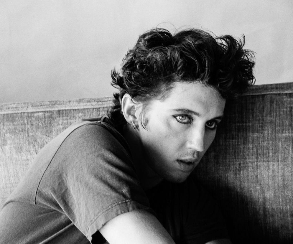 Piosenkarz Troye Sivan z makijażem oczu opiera się o kanapę. O nowym albumie artysty przeczytasz w serwisie Eska.