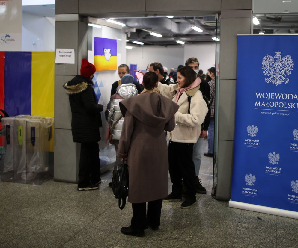Uchodźcy w punkcie informacyjnym na dworcu głównym