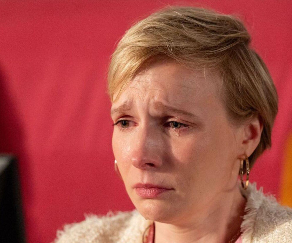 Kobieta z krótkimi, blond włosami, z łzami w oczach, patrząca w dół, ubrana w jasny, pleciony sweter. Przedstawia Sonię (Weronikę Nockowską) z serialu Barwy szczęścia w dramatycznym momencie procesu. Więcej o losach bohaterów na Super Seriale.