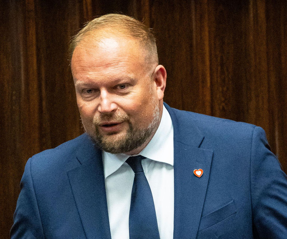 Poseł Witold Zembaczyński w niebieskiej marynarce na tle drewnianych paneli. O wydatkach na wizerunek przeczytasz na SE.