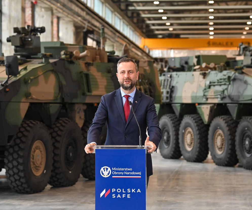 Władysław Kosiniak-Kamysz przemawiający z mównicy MON na tle wojskowych transporterów opancerzonych Rosomak w Siemianowicach Śląskich. Minister ogłasza nowe kontrakty zbrojeniowe, o których można przeczytać na Super Biznes.